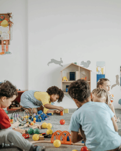 Groep jonge kinderen die spelen in een kinderopvang, als illustratie voor het belang van aanvullende vaccinaties.